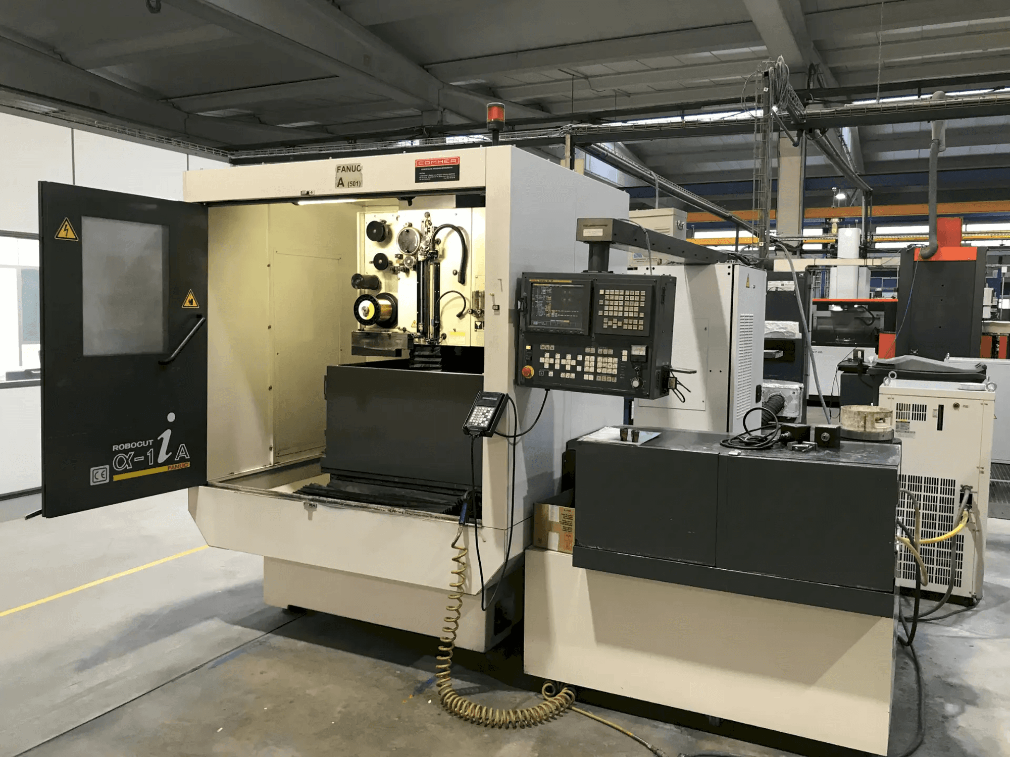 Verticaal bewerkingscentrum van Mazak met geopende deur, waarbij het gereedschap en de bedieningselementen zichtbaar zijn, zijaanzicht, voor precisiebewerkingen.