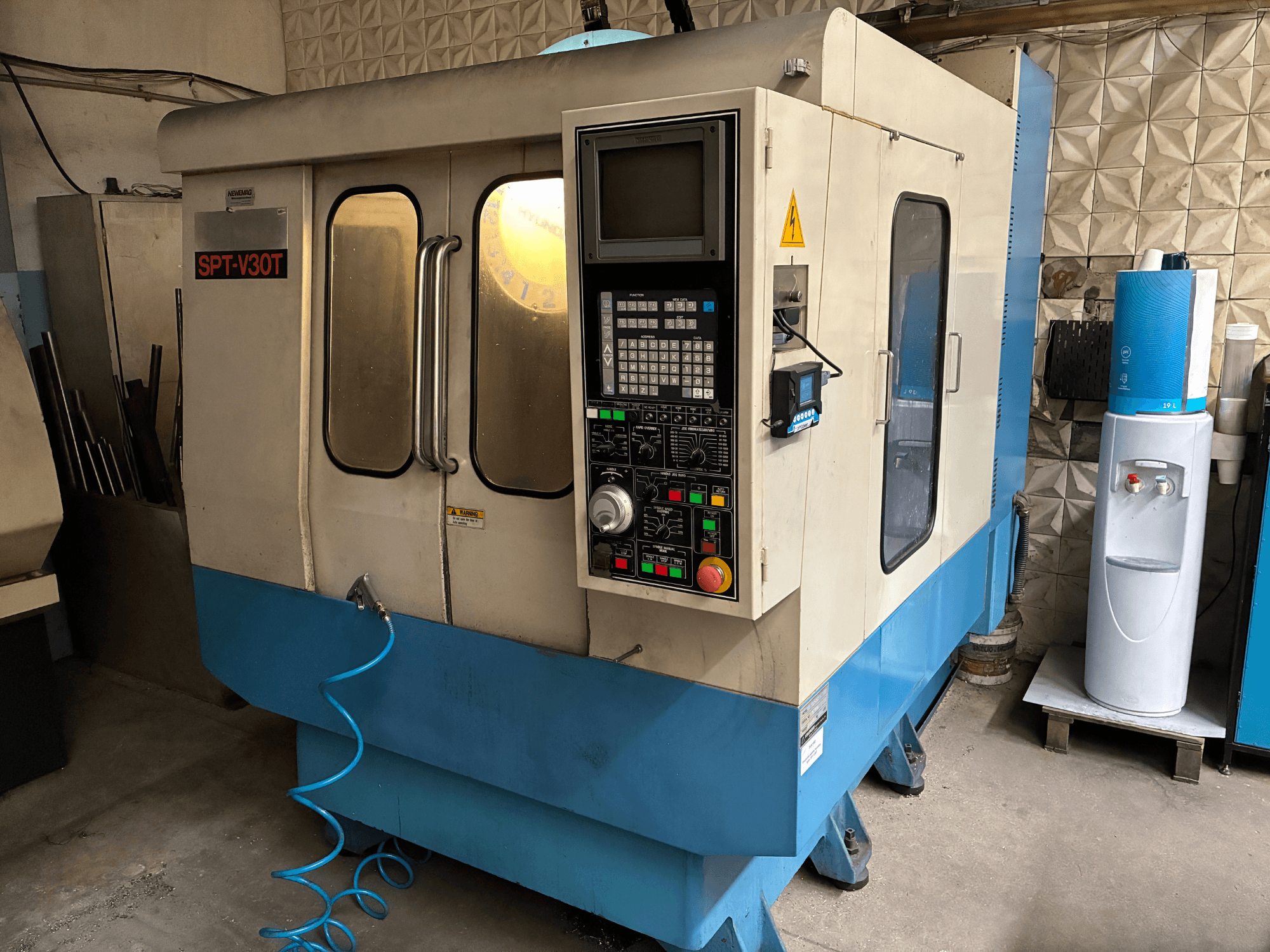 Industriële freesmachine SPT-V30T, vooraanzicht, met een bedieningspaneel, knoppen en een blauwe slang.