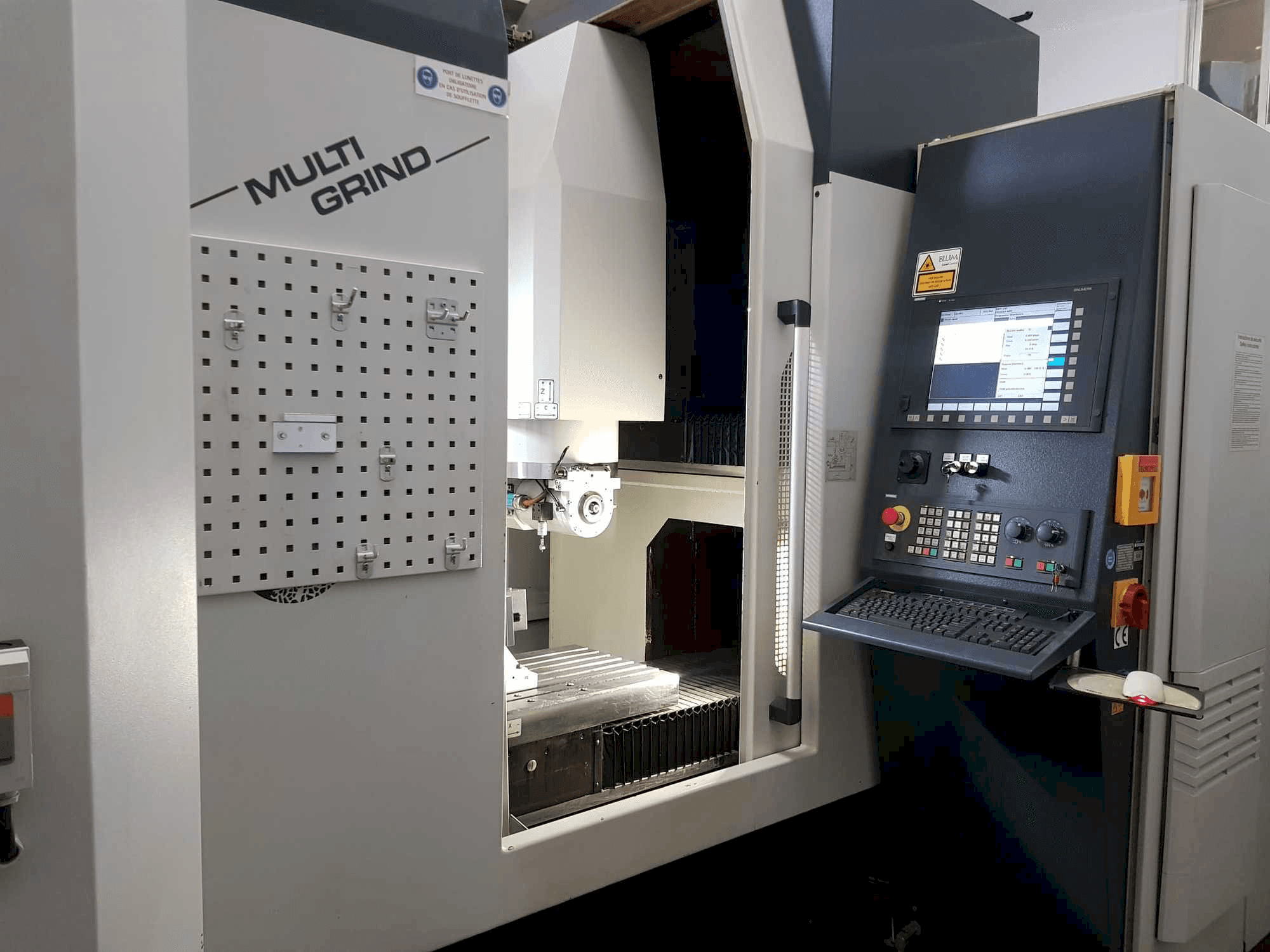 Multi Grind CNC machine met vooraanzicht, voorzien van een bedieningspaneel, opbergruimte en een open werkruimte.